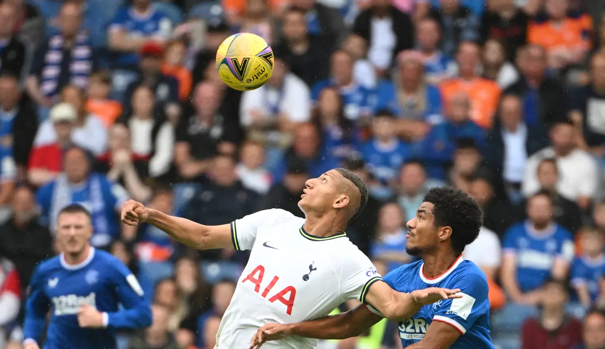 <p>Striker Tottenham Hotspur, Richarlison (kiri) berebut bola dengan gelandang Rangers, Malik Tillman pada pertandingan persahabatan di Stadion Ibrox di Glasgow (23/7/2022). Tottenham menang tipis atas Rangers 2-1. (AFP Photo/Andy Buchanan)</p>