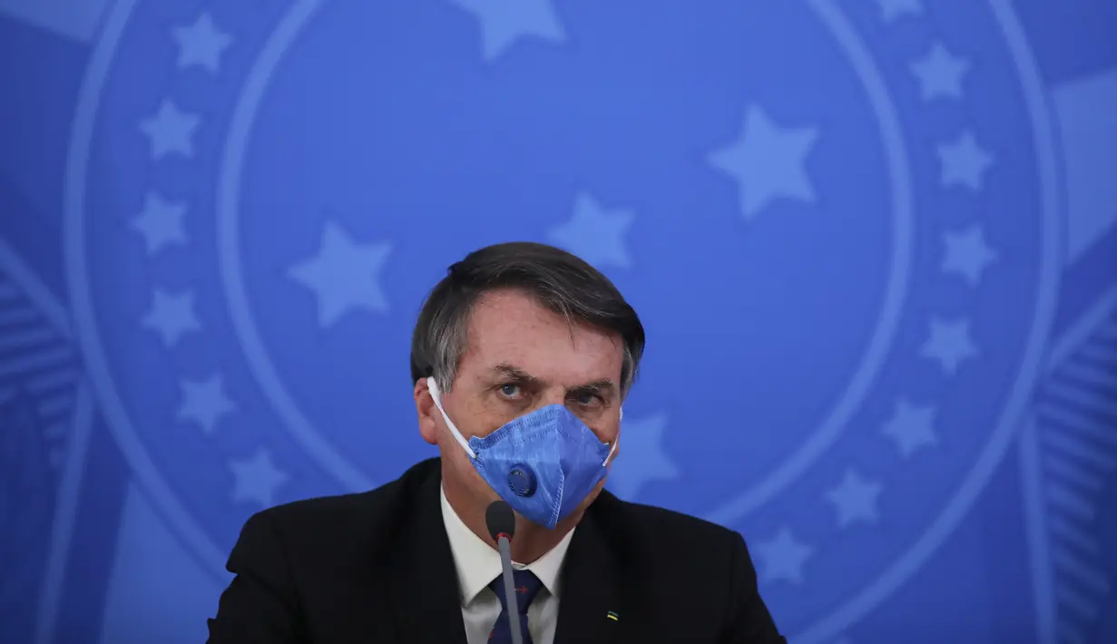 Presiden Brasil Jair Bolsonaro mengenakan masker saat konferensi pers mengenai pandemi virus corona COVID-19 di Istana Planalto, Brasilia, Brasil, 20 Maret 2020. Bolsonaro kerap menganggap ringan COVID-19 kendati Brasil menjadi salah satu pusat penyebaran COVID-19 dunia. (Sergio LIMA/AFP)