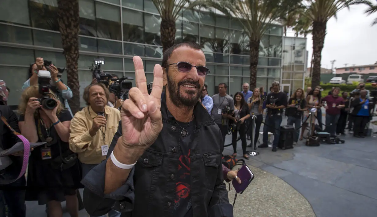 Drummer The Beatles, Ringo Starr memberi salam dua jari saat perayaan ulang tahunnya yang ke-75 di Los Angeles, California, Selasa (7/7/2015). Acara perayaan ulang tahun tersebut bertema Peace & Love. (REUTERS/Mario Anzuoni)