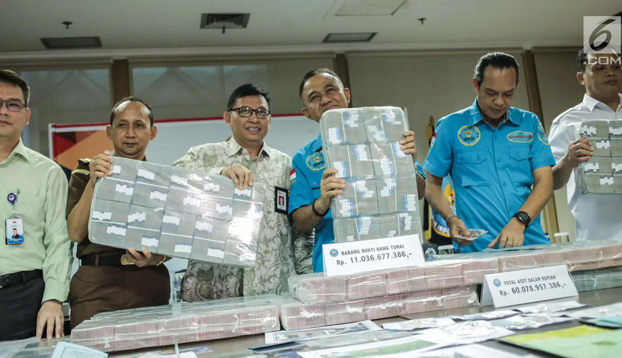 Kepala BNN Heru Winarko bersama jajaran menunjukkan barang bukti uang saat rilis di Gedung BNN, Jakarta, Kamis (25/7/2019). BNN menyita 440 Batang Kayu Jati Rp 90.000.000,  Perhiasan senilai Rp 617.000.000, Uang tunai sebesar Rp 11.036.677.386. (Liputan6.com/Faizal Fanani)