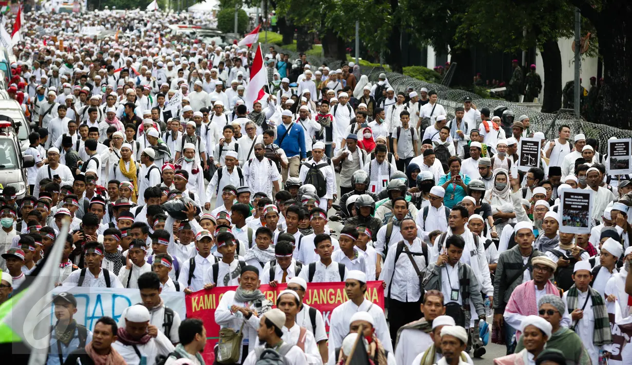 Massa demo 2 Desember mulai berjalan kaki menuju Monumen Nasional (Monas), Jakarta Pusat, Jumat (2/12). Dengan mengenakan pakaian serba putih, peserta demo 2 Desember sesekali mengucapkan kalimat takbir. (Liputan6.com/Faizal Fanani)