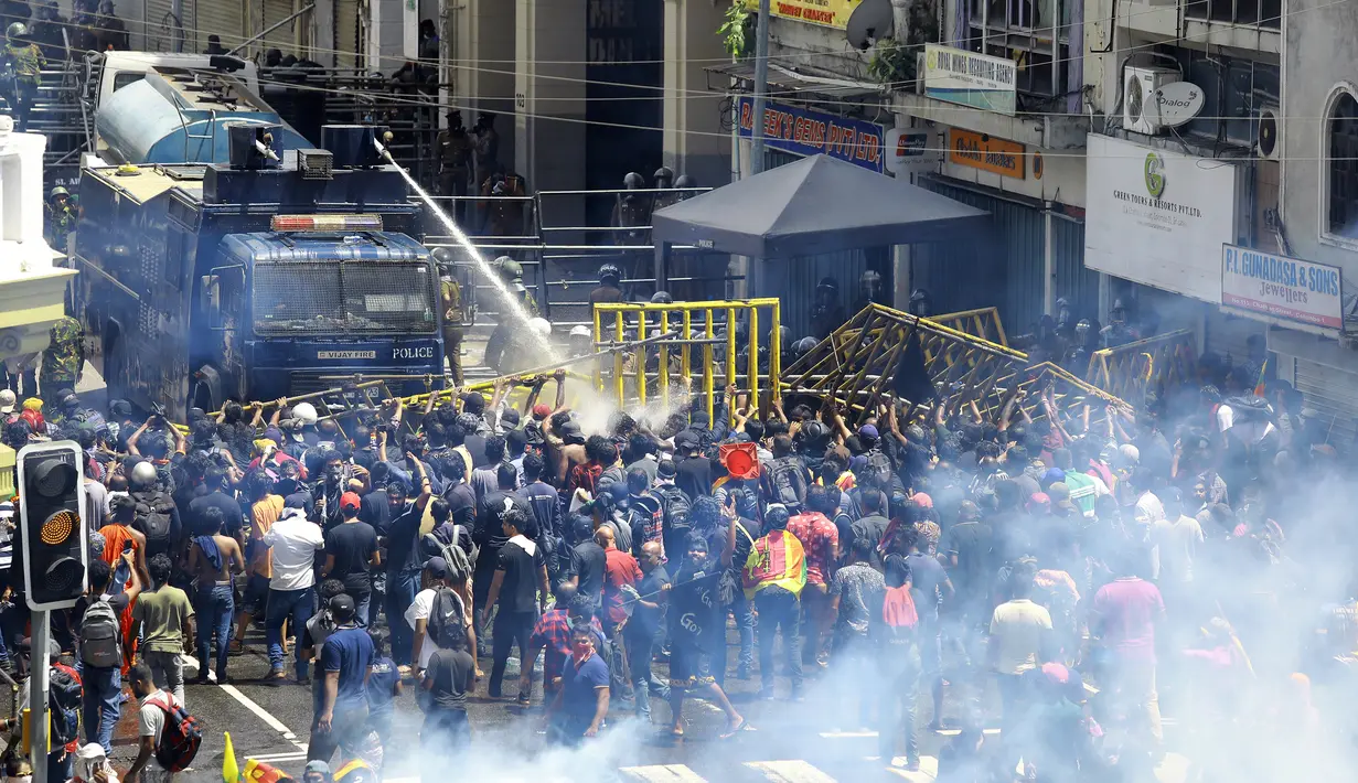 Polisi menggunakan water canon dan gas air mata untuk membubarkan para pengunjuk rasa di Kolombo, Sri Lanka, 9 Juli 2022. Sejumlah demonstran memegang bendera Sri Lanka masuk ke kediaman Presiden Gotabaya Rajapaksa di Ibu Kota Kolombo. (AP Photo/Amitha Thennakoon)