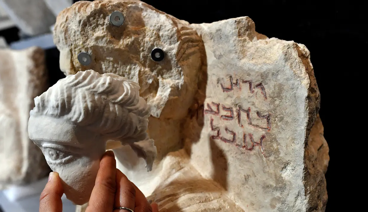 Bagian patung yang telah dibuat siap dipasangkan, Roma, Kamis (16/2). Patung-patung tersebut rusak akibat serangan dari ISIS. (AFP PHOTO / Alberto PIZZOLI)