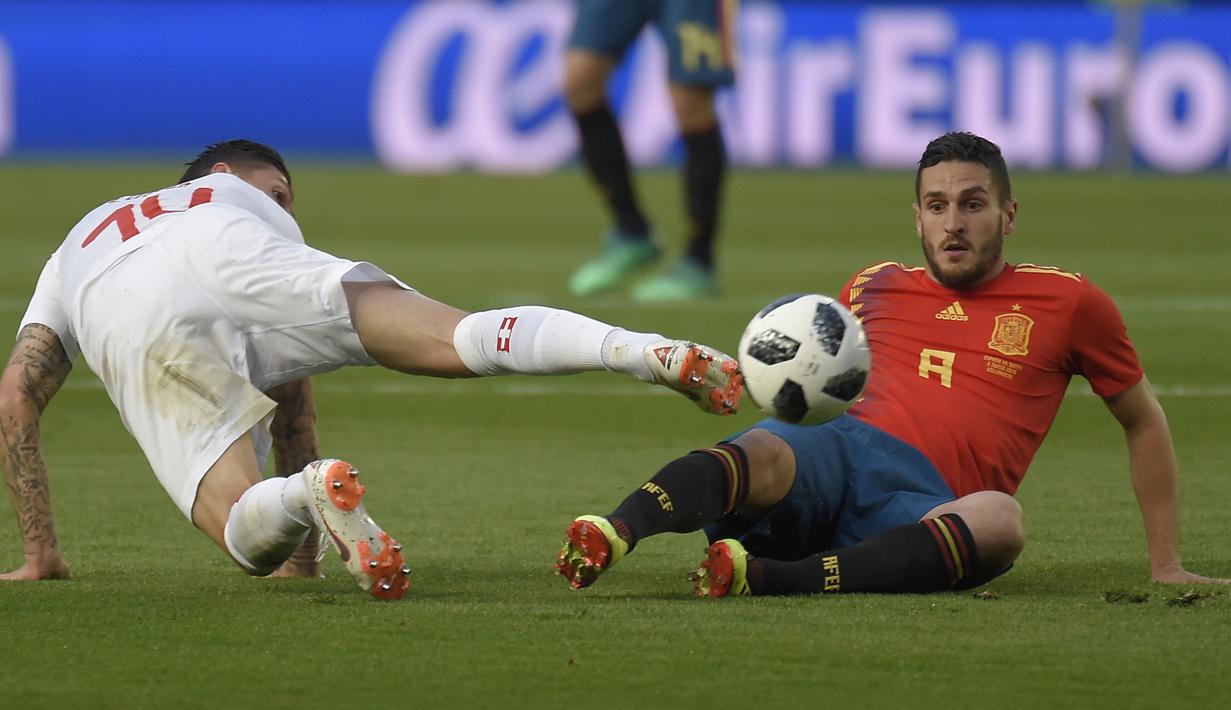 Gelandang Swiss, Steven Zuber, berebut bola dengan gelandang Spanyol, Koke, pada laga persahabatan di Stadion La Ceramica, Vila-real, Minggu (3/6/2018). Kedua negara bermain imbang 1-1. (AFP/Jose Jordan)