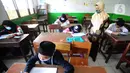 Guru mengawasi murid kelas V saat menjalani ujian Penilaian Akhir Semester (PAS) tahun pelajaran 2020/2021 di Madrasah Ibtidayah (MI) Assu'ada di Pancoran Mas, Depok, Jawa Barat, Selasa (1/12/2020). Ujian dilaksanakan dengan menerapkan protokol kesehatan dalam kelas. (merdeka.com/Arie Basuki)