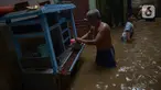 Warga beraktivitas di tengah banjir yang merendam kawasan Kebon Pala, Kampung Melayu, Jakarta Timur, Sabtu (16/7/2022). Banjir itu disebut akibat luapan Kali Ciliwung akibat hujan deras yang mengguyur wilayah Jakarta, Bogor, dan Depok sejak Jumat (15/7/2022) malam hingga Sabtu pagi. (merdeka.com/Imam Buhori)