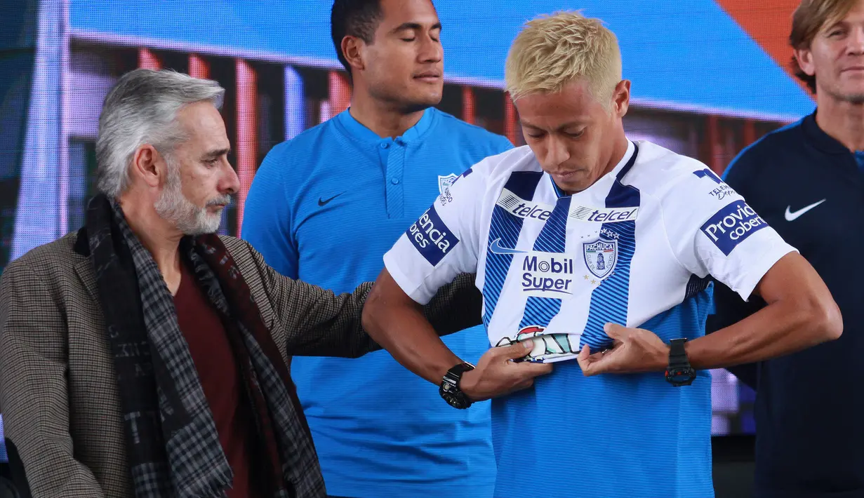 Gelandang baru Pachuca, Keisuke Honda asal Jepang memakai jersey klub barunya di samping presiden tim Jesus Martinez saat jumpa pers di Football University, Pachuca, Negara Bagian Hidalgo, Meksiko, (18/7). (AFP Photo/Victor Cruz)