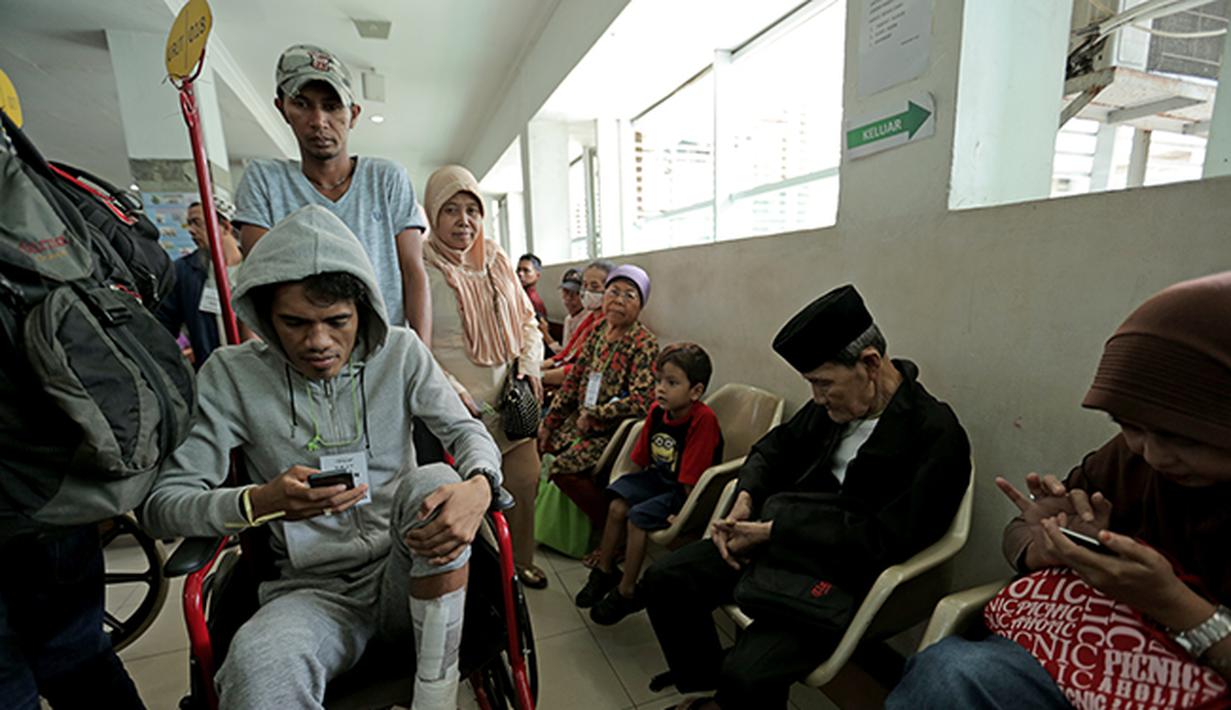 Alfin Tuasalamony membuang rasa jenuh menanti giliran waktu berkonsultasi dengan dokter.  (Bola.com/Peksi Cahyo)