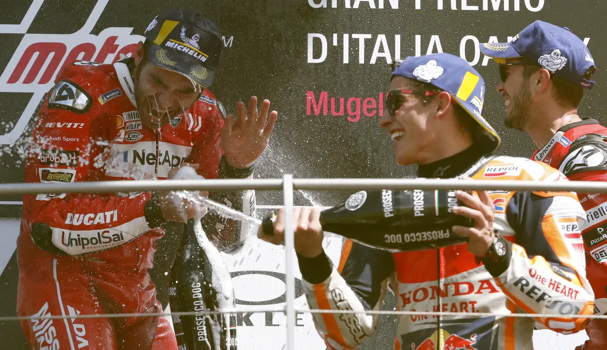 Pebalap Ducati, Danilo Petrucci, bersama Marc Marquez dan Andrea Dovizioso melakukan selebrasi usai menjuarai MotoGP Italia 2019 di Sirkuit Mugello, Minggu (2/6). Petrucci mencatatkan waktu 41 menit 33,794 detik. (AP/Antonio Calanni)