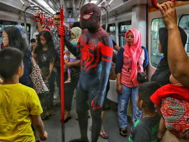 Para Spider-Man yang tergabung dalam komunitas Spider-Verse Indonesia berada di dalam kereta api ringan atau Light Rail Transit (LRT) di kawasan Jakarta, Minggu (21/7/2019). Dalam aksinya, mereka melakukan penggalangan dana untuk donasi anak penderita hydrocephalus. (Liputan6.com/Johan Tallo)