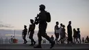 Sejumlah tentara patroli di pantai Copacabana di Rio de Janeiro, Brasil, (30/7). Ribuan tentara mulai berpatroli di Rio de Janeiro di tengah lonjakan kekerasan di kota terbesar kedua di Brasil. (AP Photo / Leo Correa)