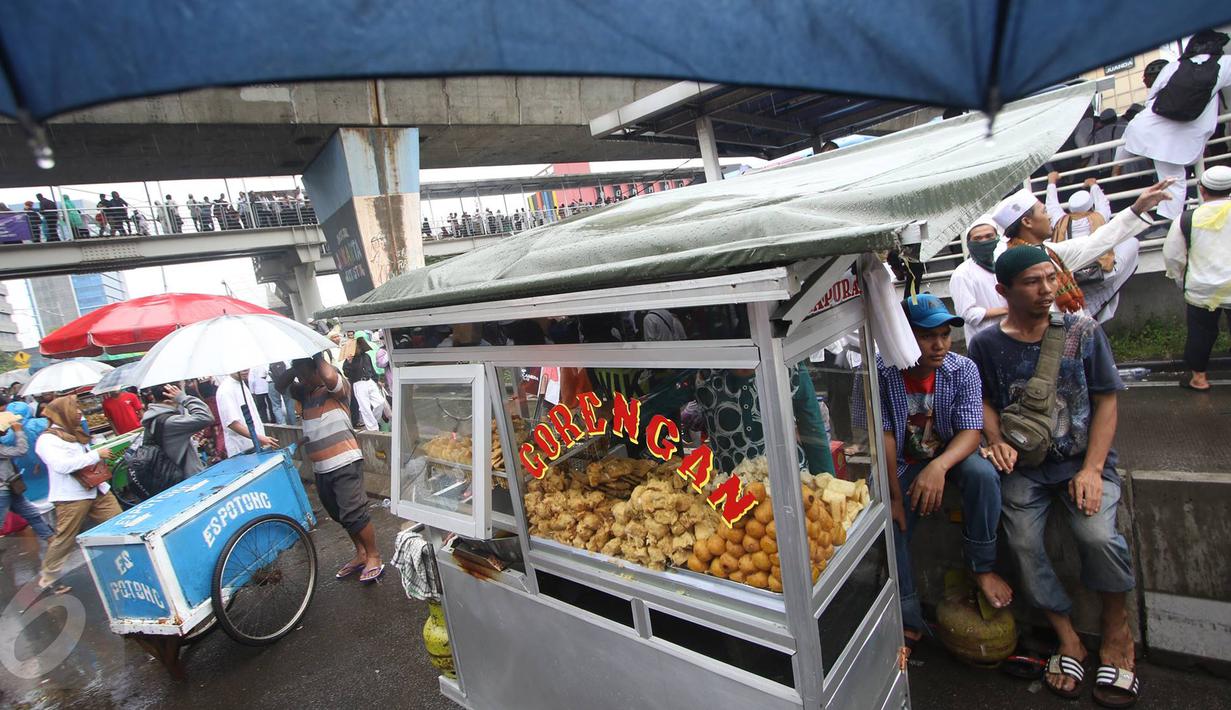 Pedagang Kaki Lima (PKL) menjajakan dagangannya di sekitar Mesjid Istiqlal, Jakarta, Jumat (2/12). Aksi 2 Desember yang dipenuhi massa menjadi kesempatan bagi sejumlah PKL untung meraup untung. (Liputan6.com/Immanuel Antonius)