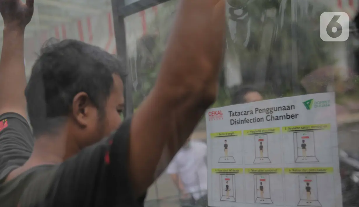 Warga masuk dalam ruang khusus semprot Desinfektan Chamber di depan Pasar Raya Blok M, Jakarta, Selasa (24/3/2020). Pamasangan ruang khusus semprot Desinfektan Chamber untuk mensterilkan full body masyarakat untuk menekan penyebaran Covid-19. (Liputan6.com/Faizal Fanani)