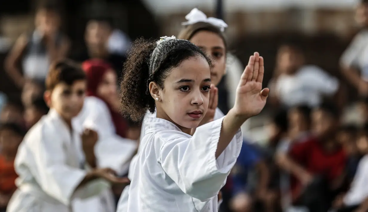 Seorang anak Palestina menunjukkan keterampilannya selama upacara promosi Karate di sebuah pusat olahraga di kamp Rafah untuk pengungsi Palestina di Jalur Gaza selatan (20/9/2019). (AFP Photo/Said Khatib)