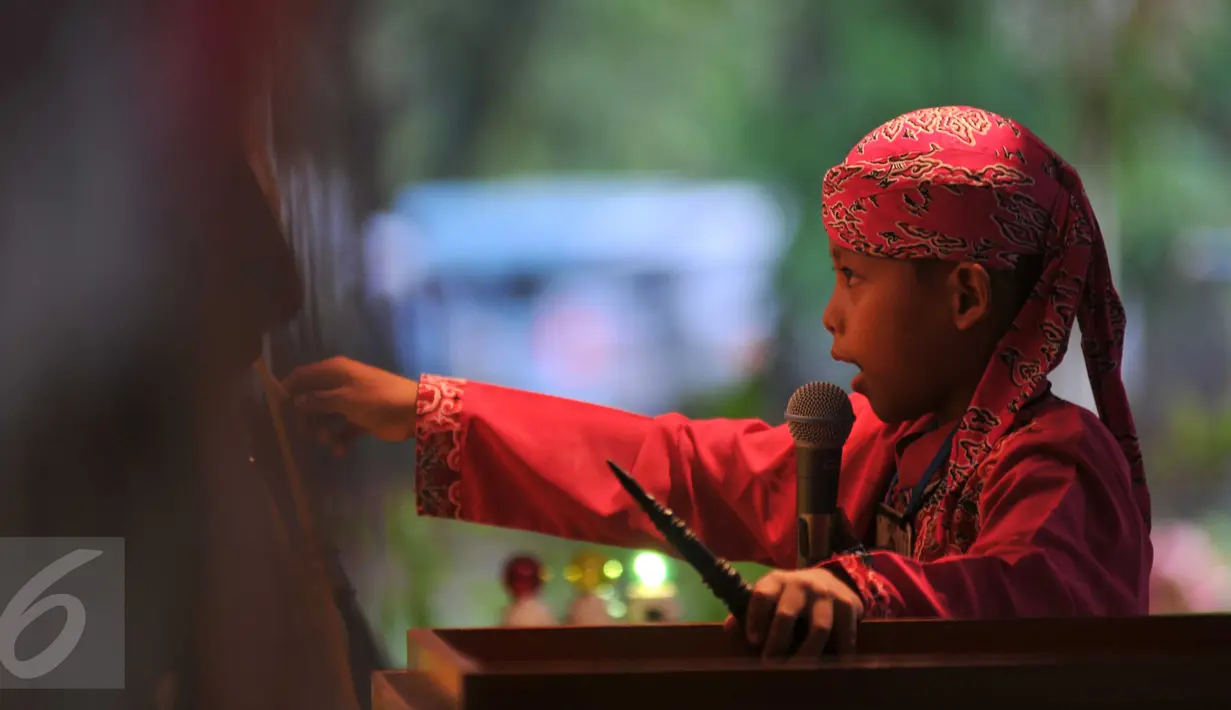 Seorang anak menunjukkan keahliannya menjadi dalang selama festival Dalang Bocah di Kawasan Kota Tua, Jakarta (20/11). Festival kali keenam ini diikut 22 peserta dari kota-kota di sekujur Pulau Jawa, Lampung dan NTB. (Liputan6.com/Gempur M Surya)