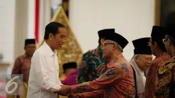 Presiden Joko Widodo berjabat tangan dengan Ketua Umum PP Muhammadiyah Haedar Nashir sebelum melakukan pertemuan di Istana Merdeka, Jakarta, Selasa (1/11). (Liputan6.com/Faizal Fanani)