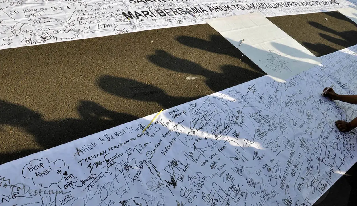 Ribuan warga ikut memberikan dukungan  menolak RUU Pilkada dengan membubuhkan pesan dan tanda tangannya di atas banner putih sekitar tiga meter, Jakarta, (14/9/14). (Liputan6.com/Miftahul Hayat)