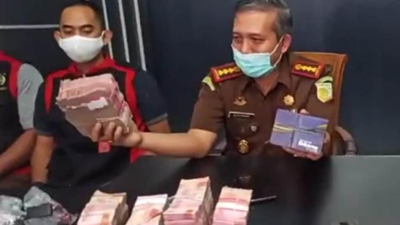 Kajari Purwokerto, Sunarwan, (kiri) menunjukkan barang bukti uang tunai Rp 470 juta yang disita dari rumah seorang saksi kasus dugaan korupsi dana JPS Kemenaker. (Foto: Liputan6.com/Kejari Purwokerto)
