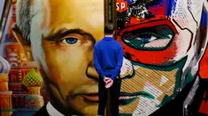 Seorang pria melihat sebuah lukisan yang menggambarkan Presiden Rusia Vladimir Putin dalam pameran Superputin di Museum Umam, Moskow (6/12). (AFP Photo/Yuri Kadobnov)
