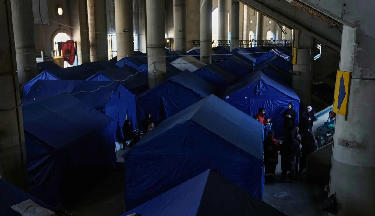 Langkah darurat ini diambil menyusul eskalasi konflik antara Israel dan Hizbullah yang pecah kembali sejak Maret 2026. Tampak dalam foto, para pengungsi berdiri di samping tenda-tenda yang didirikan di dalam Camille Chamoun Sports City Stadium, yang telah diubah menjadi tempat penampungan bagi orang-orang yang melarikan diri dari serangan udara Israel di Lebanon selatan, Beirut, Lebanon, Rabu 8 April 2026. (AP Photo/Bilal Hussein)