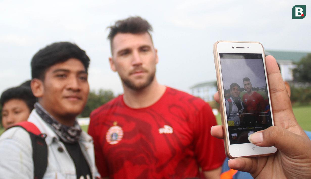 Striker Persija Jakarta, Marko Simic foto bersama penggemarnya usai latihan di Lapangan Sutasoma, Jakarta, Senin (12/3/2018). Persija berlatih jelang laga Piala AFC melawan Song Lam Nghe An. (Bola.com/Asprilla Dwi Adha)
