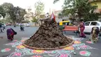 Warga menghiasi jalan di sekitar "Holika", Ahmedabad, India, Minggu (12/3). Bahan bakar Holika adalah kue yang terbuat dari kotoran sapi dan kelapa. (AFP PHOTO / SAM PANTHAKY)