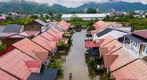 Foto udara menunjukkan seorang pria melintasi banjir setelah hujan deras di permukiman Darul Imarah di pinggiran Banda Aceh pada Kamis 27 November 2025. Curah hujan tinggi yang dipicu siklon tropis menyebabkan sejumlah wilayah di Aceh Besar, termasuk Darul Imarah, terendam banjir. (CHAIDEER MAHYUDDIN/AFP)