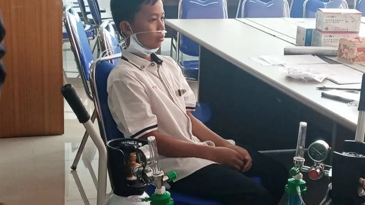 Seorang siswa Abdurrab Islamic School diberi oksigen karena sesak napas akibat menghirup kabut asap Karhutla.