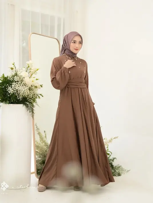 <p>Atau untuk kamu yang butuh tampilan lebih kasual, namun tetap terkesan elegan, di sini Citra Kirana terlihat mengenakan flowy long dress berwarna cokelat polos, dengan detail belt di bagian pinggang dan payet untuk mempermanis area dada. Foto: Instagram.</p>
