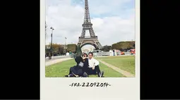 Fitri dan sang suaminya berpose duduk dengan berlatar belakang Menara Eiffel, (13/10/14). (instagram.com/fitrop) 