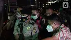 Terpidana kasus pembalakan liar dan perusakan alam, Adelin Lis (tengah) saat tiba di Gedung Penerangan Kejaksaan Agung, Jakarta, Sabtu (19/6/2021). Adelin Lis ditangkap di Singapura dan dipulangkan ke Indonesia setelah buron selama 13 tahun. (Liputan6.com/Helmi Fithriansyah)