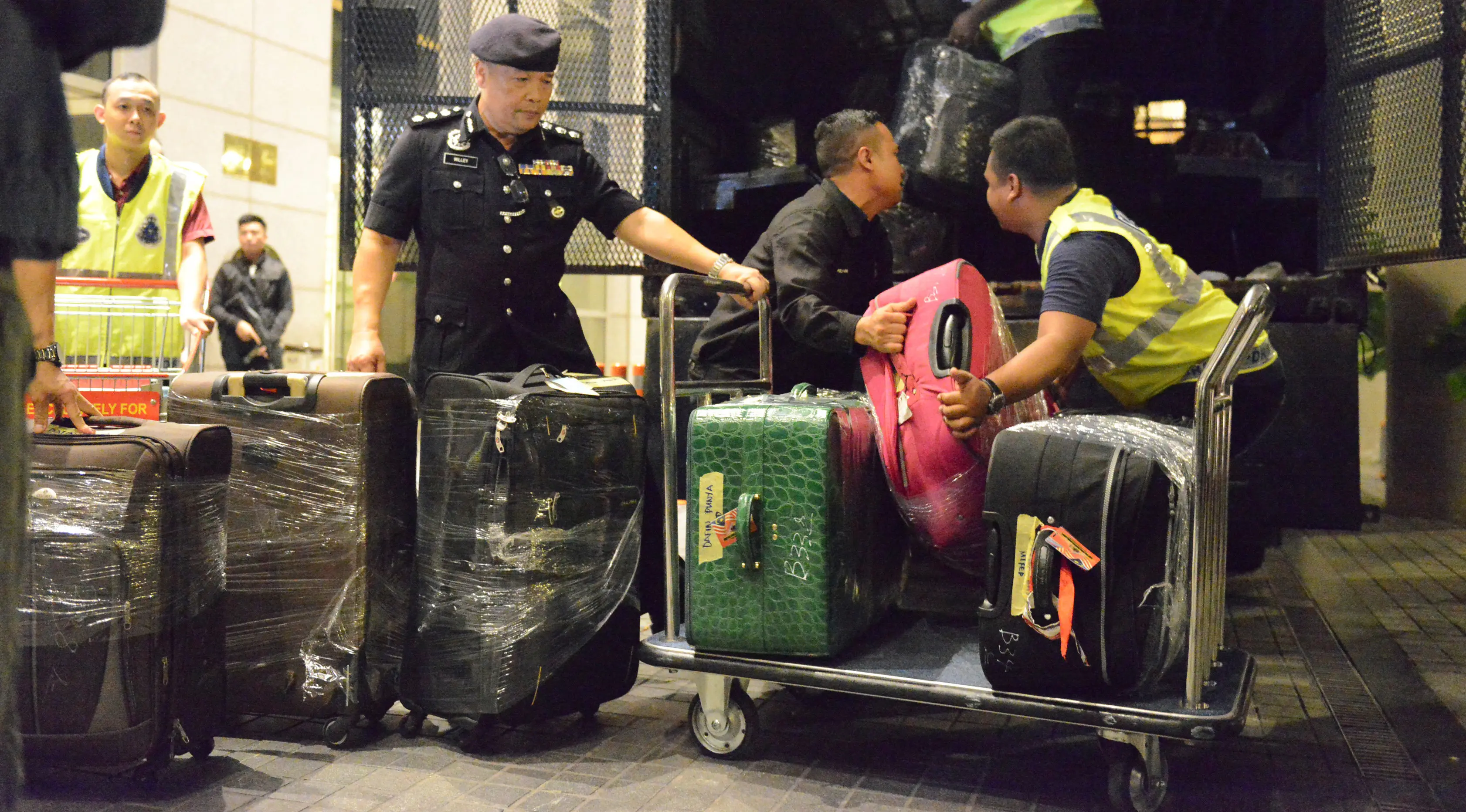 Polisi Malaysia memasukkan sejumlah koper berisi barang-barang yang disita dari tiga apartemen mantan Perdana Menteri Najib Razak di Kuala Lumpur, Jumat (18/5). Selain tas mewah, polisi juga menyita 72 tas bagasi berisi uang tunai dan perhiasan (AP Photo)