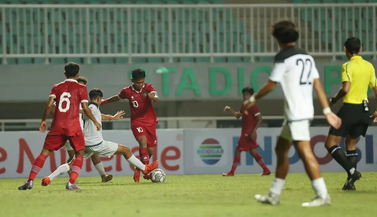Pemain Timnas Indonesia U-17 Muhammad Nabil Asyura berebut bola dengan Timnas Guam U-17  dalam laga Kualifikasi Piala Asia U-17 2023 Grup B di Stadion Pakansari, Cibinong, Kabupaten Bogor, Jawa Barat, Senin (3/10/2022). Tim besutan Bima Sakti Tukiman itu menghajar Guam 14-0 pada laga pertama. (FOTO: Dok. PSSI)