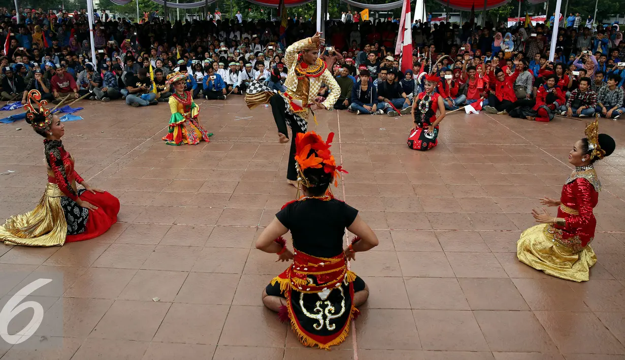 Mahasiswa yang tergabung dalam organisasi atau gerakan kemahasiswaan menonton tarian di acara Apel Kebangsaan Mahasiswa Indonesia di Tugu Proklamasi, Jakarta, Kamis (3/11). (Liputan6.com/Johan Tallo)