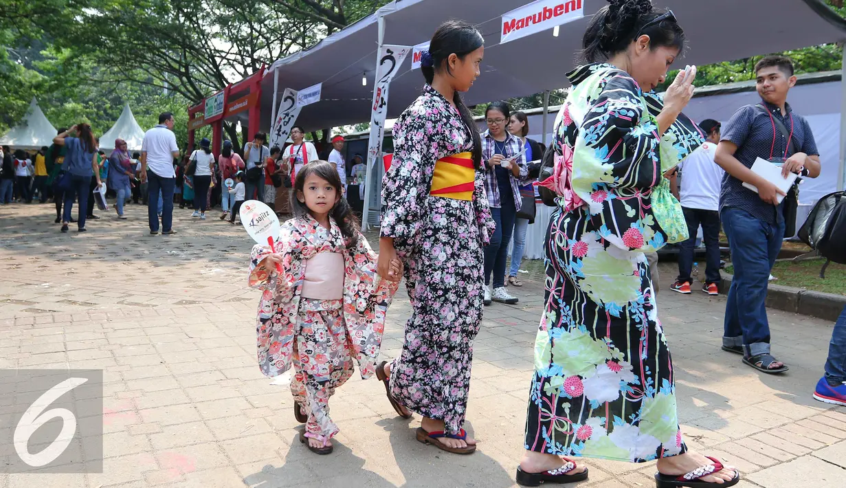 Pengunjung berjalan menggunakan kimono saat festival Jak-Japan Matsuri 2016 di Senayan, Jakarta, Sabtu (3/9). Festival tersebut sekaligus untuk memperingati 60 tahun hubungan diplomatik Indonesia-Jepang. (Liputan6.com/Angga Yuniar)