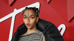 FKA Twigs berpose untuk fotografer setibanya di British Fashion Awards di London, Senin, 5 Desember 2022. Wanita berusia 34 tahun itu menarik perhatian banyak orang dengan penampilannya yang unik, yaitu wajahnya ditutupi bintik-bintik gelap dalam pola melingkar. (AFP/DANIEL LEAL)