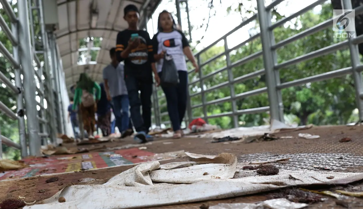 Sampah berserakan di koridor Jembatan Penyebrangan Orang (JPO) Jalan Medan Merdeka Barat, Jakarta, Selasa (1/1). Hal ini mengganggu kenyamanan warga yang melintas di JPO Medan Merdeka Barat. (Liputan6.com/Helmi Fithriansyah)