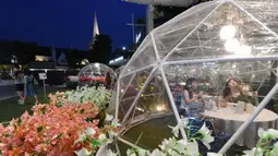 Orang-orang menyantap makanan dalam dining dome, instalasi tempat makan berbentuk kubah yang membantu mencegah penyebaran COVID-19, di Capitol Singapore Outdoor Plaza, Singapura, 21 Oktober 2020. (Xinhua/Then Chih Wey)