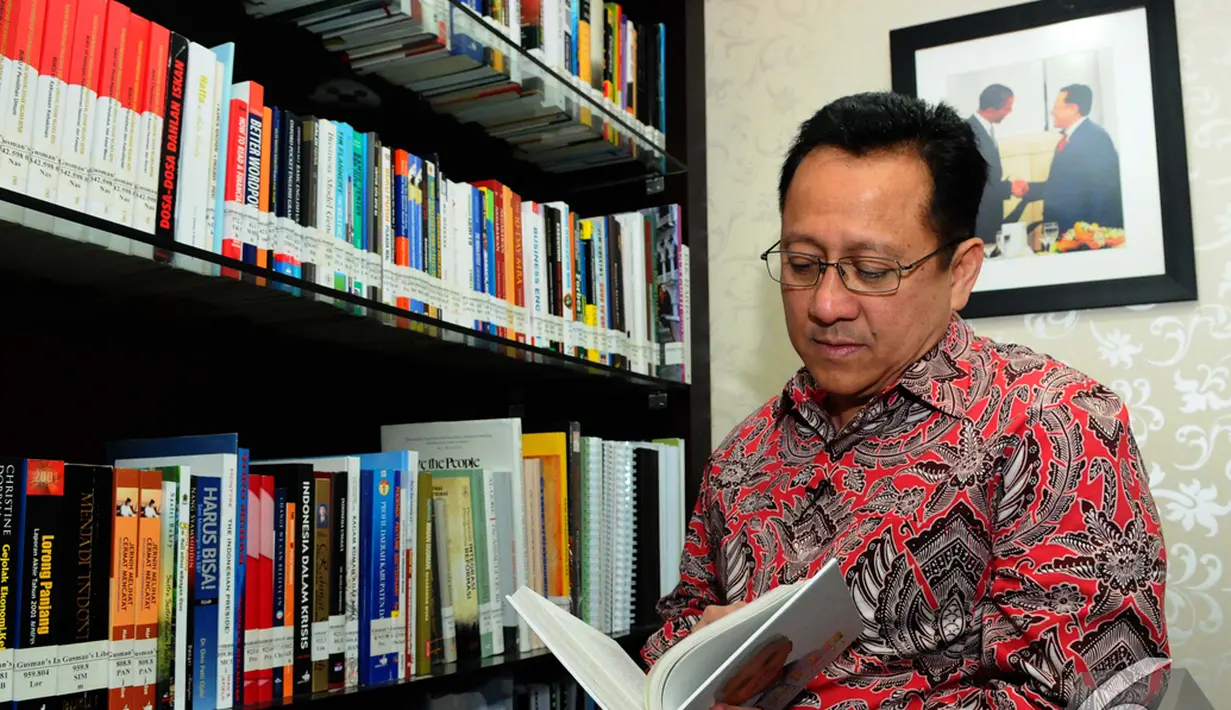 Irman Gusman tampak membaca buku saat Liputan6.com berkunjung ke kediaman pribadinya, Jakarta, Rabu (3/12/2014). (Liputan6.com/Andrian M Tunay)