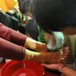 Seorang narapidana anak membasuh kaki ibunya di Lembaga Pembinaan Khusus Anak (LPKA) Kelas 1 Tangerang, Banten (17/4). Kegiatan ini dilakukan serentak di seluruh LPKA di Indonesia. (Merdeka.com/Arie Basuki)