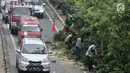 Kendaraan melintas saat petugas Suku Dinas Kehutanan Jakarta Timur menebang pohon di pinggir Jalan I Gusti Ngurah Rai, Jakarta, Rabu (25/7). Penebangan dilakukan untuk mengantisipasi terjadinya pohon tumbang. (Merdeka.com/Iqbal Nugroho)