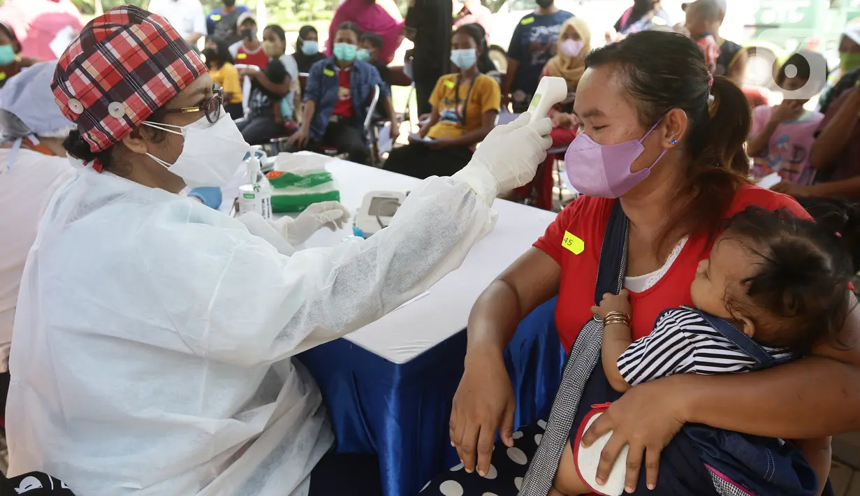 Petugas kesehatan memeriksa kesehatan warga sebelum vaksinasi di area TPST Bantargebang, Bekasi, Jumat (29/10/2021). Pihak penyelenggara menyediakan 1000 dosis untuk vaksinasi pertama maupun kedua bagi masyarakat dan komunitas pemulung di sekitar TPST Bantargebang. (Liputan6.com/Helmi Fithriansyah)