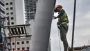 Pekerja saat menyelesaikan pembangunan Tugu Sepeda di Jalan Jenderal Sudirman, Jakarta, Senin (5/4/2021). Pembangunan tugu ini berbentuk satu buah ban sepeda berukuran raksasa. (merdeka.com/Iqbal S. Nugroho)