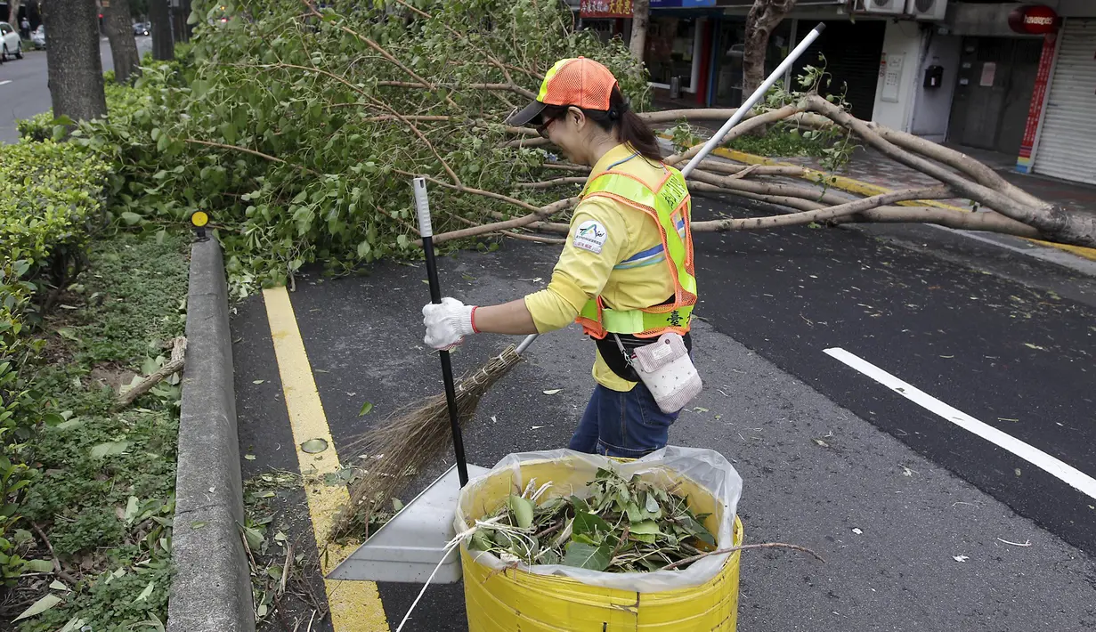 Seorang pekerja terlihat menyingkirkan pohon tumbang akibat diterjang Topan Dujuan di Taipei, Taiwan, Selasa (29/9/2015). 24 orang mengalami cedera akibat topan raksasa Dujuan. (REUTERS/Pichi Chuang)