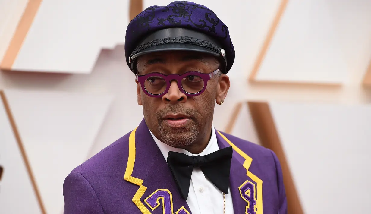 Sutradara Spike Lee tiba di karpet merah ajang Academy Awards ke-92 atau Oscar 2020 di Dolby Theatre, Los Angeles, Minggu (9/2/2020). Spike Lee menggunakan tuksedo berwarna ungu dan emas yang dikhususkan untuk mengenang legenda basket, Kobe Bryant. (Jordan Strauss/Invision/AP)