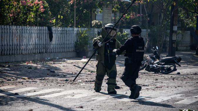 Petugas Gegana Brimob Jawa Timur menyisir lokasi ledakan bom di sekitar gereja di Surabaya, Minggu (13/5). Ledakan terjadi di tiga gereja, yakni Santa Maria di Ngagel, GKI di Jalan Diponegoro dan dan sebuah gereja di Jalan Arjuna. (AFP/JUNI KRISWANTO)