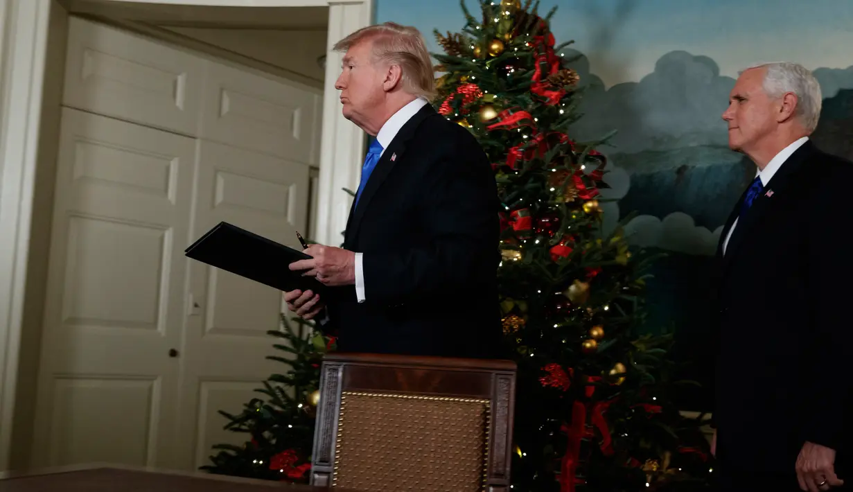 Presiden AS Donald Trump didampingi wakilnya Mike Pence membawa dokumen pengumuman Yerusalem usai ditandatangani di Ruang Penerimaan Diplomatik Gedung Putih, Washington, Rabu (6/12). (AP Photo / Evan Vucci)