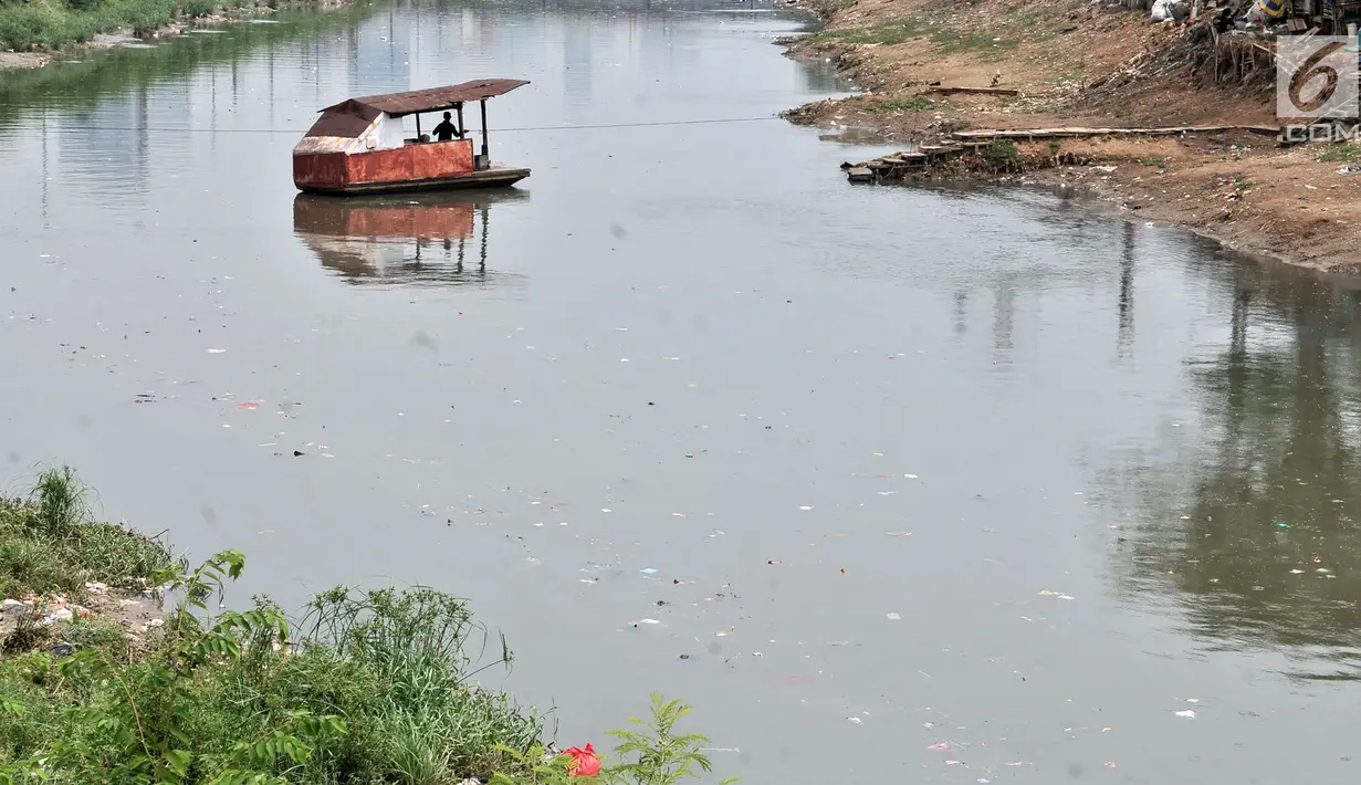 Perahu getek melintasi aliran Kanal Banjir Barat yang tengah dipenuhi sampah, Jakarta, Senin (22/10). Sampah yang memenuhi aliran kanal pencegah banjir tersebut didominasi plastik dan limbah rumah tangga. (Merdeka.com/Iqbal Nugroho)