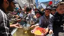 Orang-orang berebut untuk mendapatkan makanan hangat di kamp pengungsi Palestina, Nuseirat, Jalur Gaza Tengah pada Kamis 7 Mei 2026. Krisis kemanusiaan di Gaza per Mei 2026 mencapai titik kritis. (Eyad Baba/AFP)