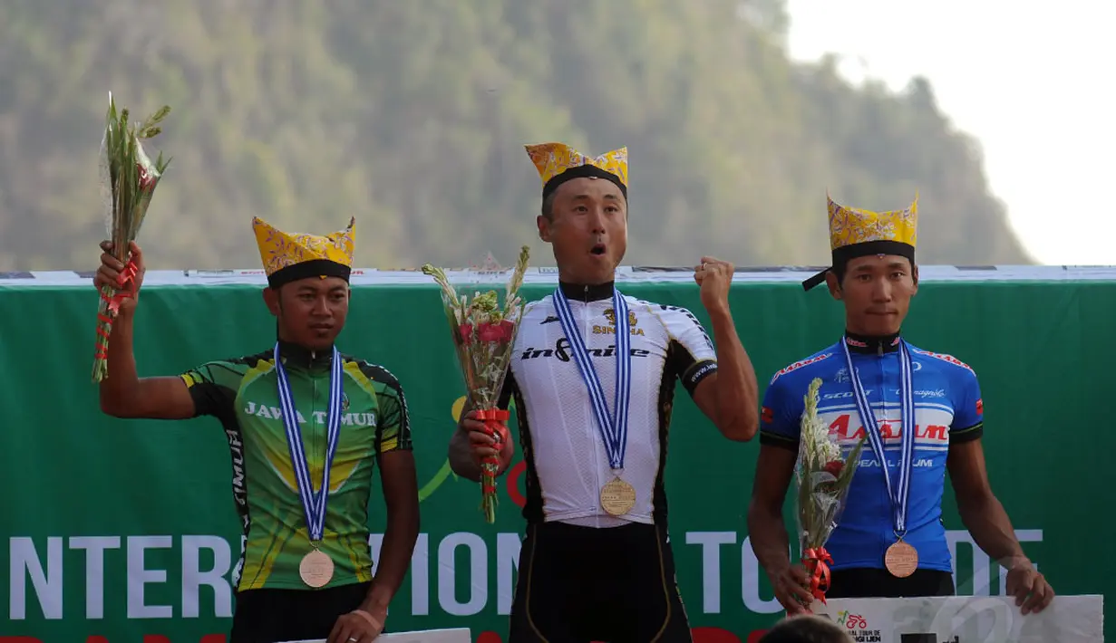 Ekspresi Kyosuke Takei (tengah) di podium kemenangan etape I balap sepeda International Tour de Banyuwangi Ijen, (16/10/2014). (Liputan6.com/Helmi Fithriansyah)